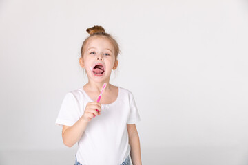Happy child kid girl brushing teeth with toothbrush on white background. Health care, dental...