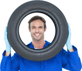 Confident mechanic looking through tire