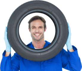 Confident mechanic looking through tire