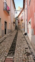 Fototapeta na wymiar A narrow alley in Lisbon where people walk