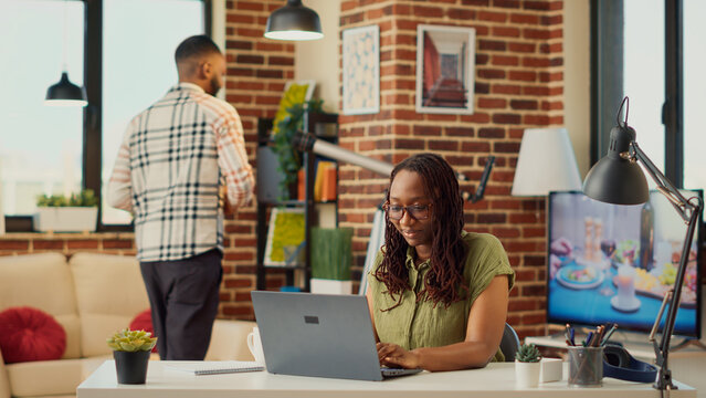 African american woman working remote from home, analyzing online information to plan accounting sales report. Using financial data on internet to send email, startup company job.