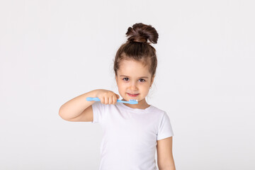 Happy child kid girl brushing teeth with toothbrush on white background. Health care, dental hygiene. Mockup, copy space