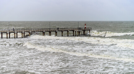 Tides and storms at sea. Sea pier. Waves on the Baltic Sea. Deserted seashore.