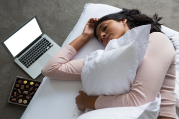 High angle view of young woman sleeping on bed