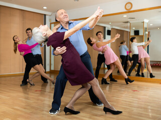 active elderly people attend dance lessons for amateurs and learn to dance waltz in their free time