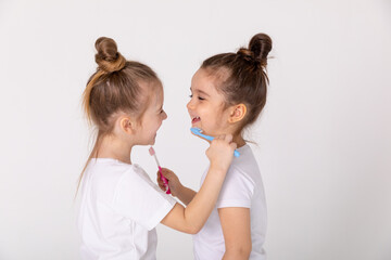 Adorable little girls with tooth brushes. Fun home play. Children smile. Healthy lifestyle, not...