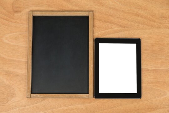 Chalk board and digital tablet on wooden background