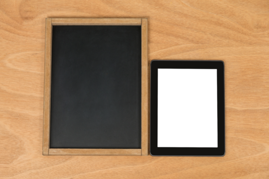 Chalk board and digital tablet on wooden background