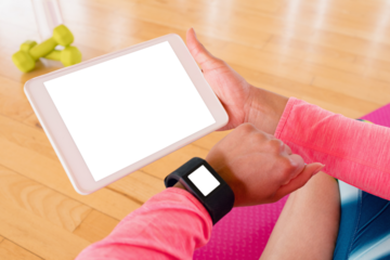 Woman holding digital tablet while using smartwatch
