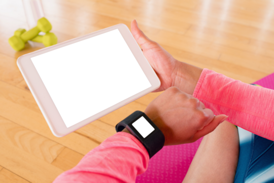 Woman holding digital tablet while using smartwatch