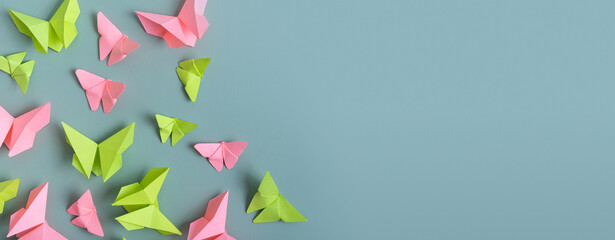 Banner with paper butterfies green and pink colors flat lay on a colored background. Copy space