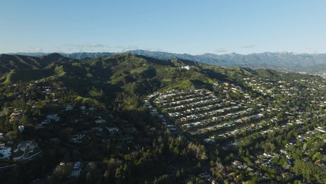 Drone shots of mansions on Hollywood Hills in Los Feliz area in Los Angeles, California. Scenic aerial shot of Los Angeles streets with expensive houses on Hollywood Hills at Griffith Observatory park