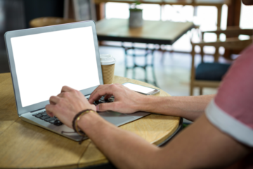Cropped hands of man using laptop