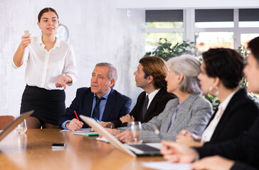 Group of diverse business people attending meeting in conference room, discussing work plan