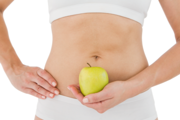 Fit woman holding an apple in front of her belly