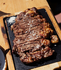 Filete de chuletón a la parrilla sobre tabla de madera. Carne a la parrilla con salsa.
