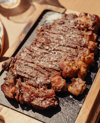 Filete de chuletón a la parrilla sobre tabla de madera. Carne a la parrilla con salsa.
