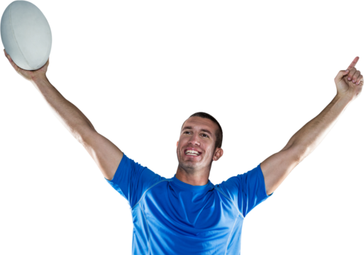 Happy rugby player in blue jersey holding ball with arms raised