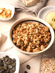 Organic muesli ingredients on a rustic white wooden table, healthy breakfast concept