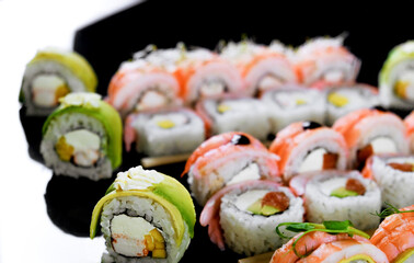 Sushi set on a black background. Fresh variety of rolls in a Japanese restaurant. Eastern cuisine.