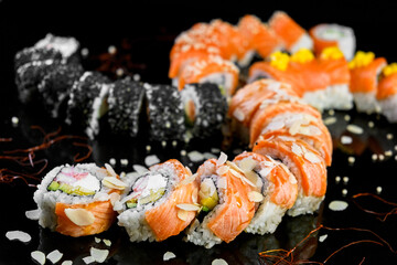 Sushi set on a black background. Fresh variety of rolls in a Japanese restaurant. Eastern cuisine.