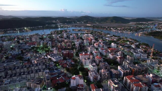 Drone sobrevoando a cidade do litoral de Cabo Frio no Rio de Janeiro Brasil, com casas e pr&eacute;dios rio que desagua no mar.