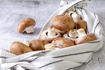 Brown champignons in a kitchen towel on the table