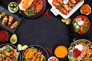 Mexican food frame. Overhead view on a dark stone background. Tacos, burrito plate, nachos, enchiladas, tortilla soup and salad. Copy space.