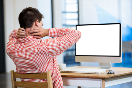 Businessman sitting by computer - Powered by Adobe