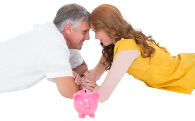 Casual couple lying on floor with piggy bank