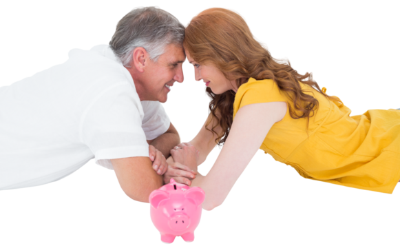 Casual couple lying on floor with piggy bank
