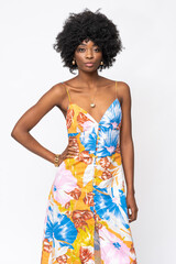 Fashionable African woman with curly hairs and floral dress on isolated white background.