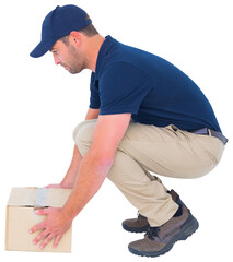 Delivery man crouching while picking cardboard box