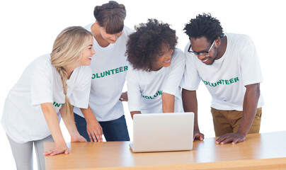 Smiling volunteers working together on a laptop