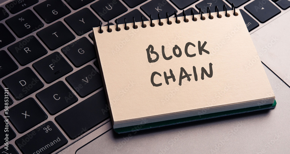 Poster there is note book with the word blockchain on a laptop. it is an eye-catching image.