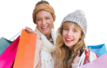 Smiling women looking at camera with shopping bags 