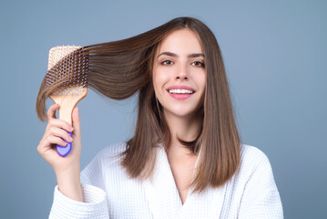 Young woman combing hair. Beautiful woman brush healthy hairs. Hairstyle and haircare concept. Girl...
