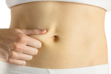 Slim woman pinching her belly