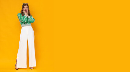 Shocked young woman with funny face on isolated yellow background.