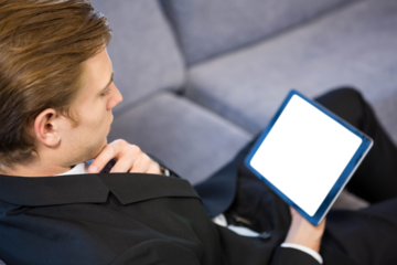 Man looking at digital tablet while sitting