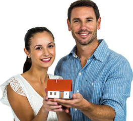 Smiling couple holding house model