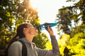 Fototapeta na wymiar Active sporty female outdoors drinking from bottle of water 