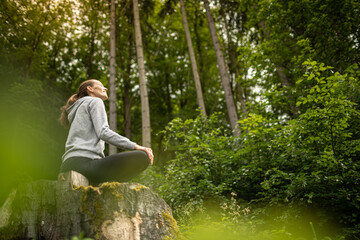 Young happy woman feeling at peace in nature forest 