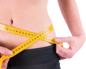 Slim woman measuring waist with tape measure