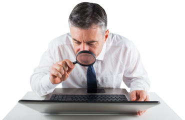 Mature businessman examining with magnifying glass