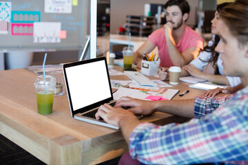 Fototapeta premium Man using laptop while working with team