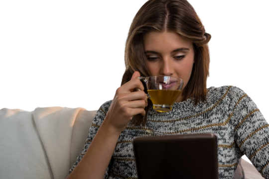 Woman having tea while using tablet - Powered by Adobe