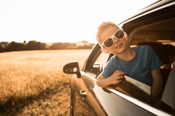 Portrait of happy little boy in car, summer fun family roadtrip 
