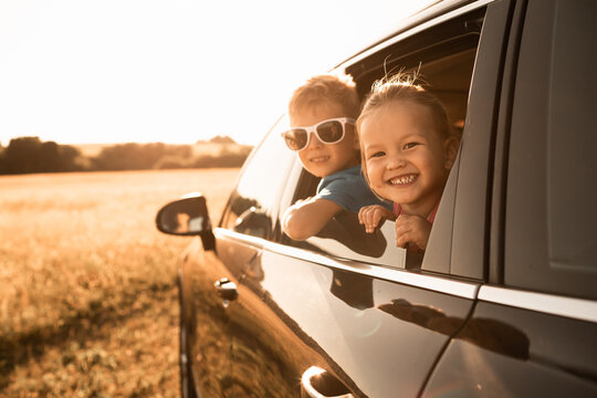 Portrait of happy little boy and girl in car. Family road trip,  summer holiday travel concept. 