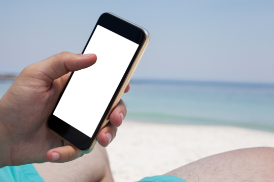 Close up of man using smartphone at beach